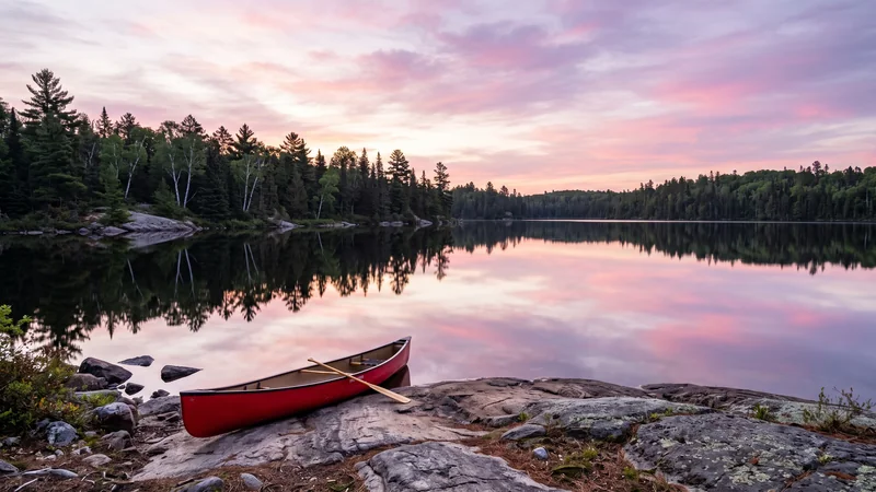 Boundary Waters lake at dawn with canoe, Minnesota