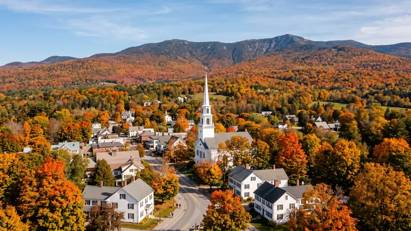 Church steeple amid autumn foliage with Mt. Mansfield, Vermont