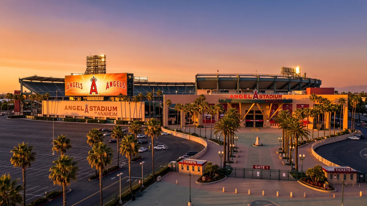 Angel Stadium in Anaheim at sunset with the Big A halo scoreboard lit up and fans walking toward the Home Plate Gate