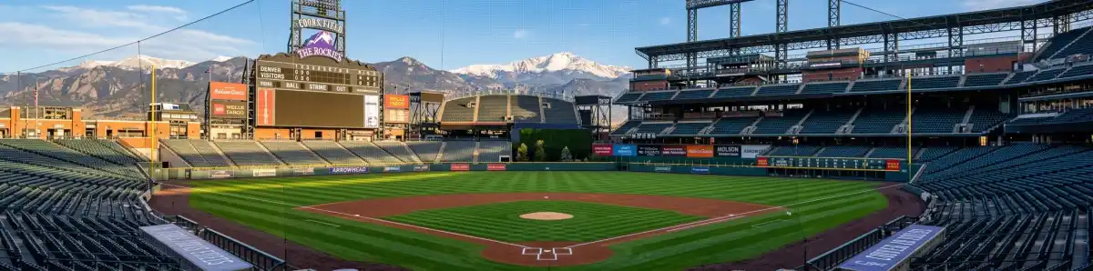 Inside Coors Field looking at the baseball field from behind home plate with the Rocky Mountain backdrop