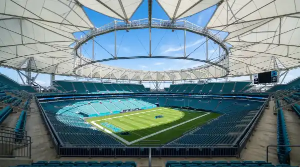 Inside Hard Rock Stadium looking across the football field with the canopy roof