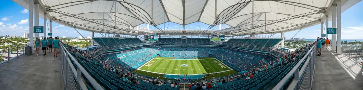 View from upper deck of Hard Rock Stadium looking down at the football field and canopy roof