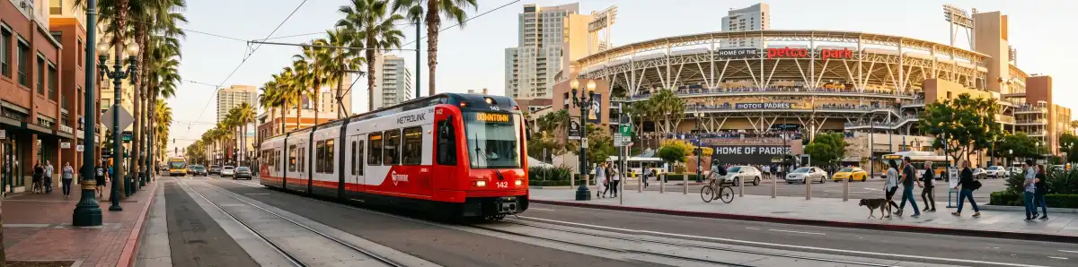 San Diego Trolley train with Petco Park visible in background, urban downtown setting with palm trees