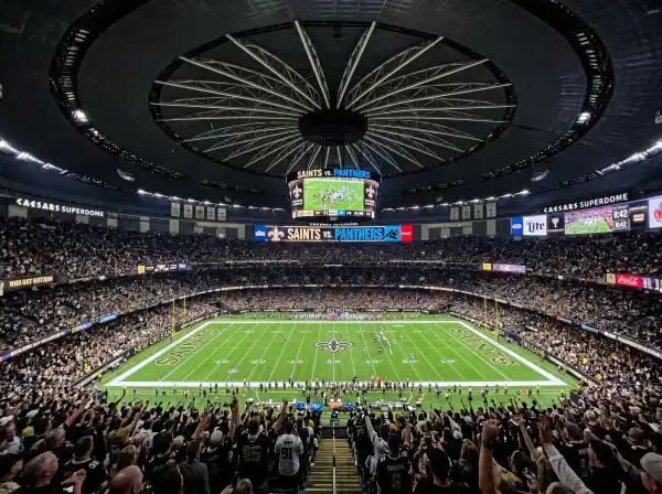 Inside the Caesars Superdome looking across the football field with the dome ceiling above
