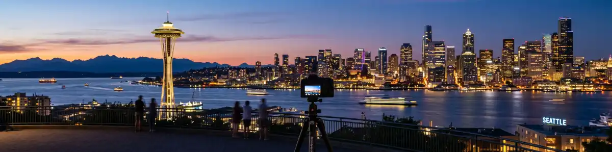 Seattle skyline at dusk with waterfront and Mount Rainier in the background with city lights reflecting