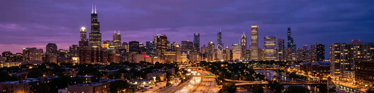 Chicago skyline at night with the Willis Tower and city lights reflecting off the Chicago River