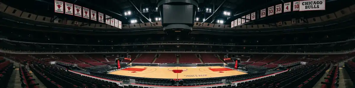 Inside the United Center arena looking across the basketball court with championship banners hanging from the rafters